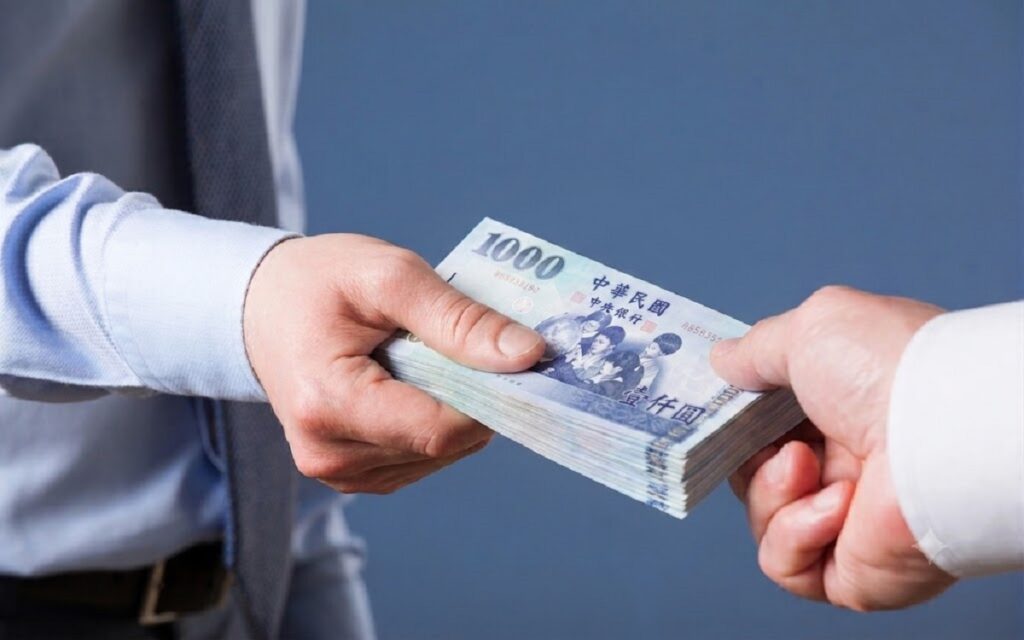 苗栗小額借款資金撥款示意，一疊千元鈔票交付到借款人手中